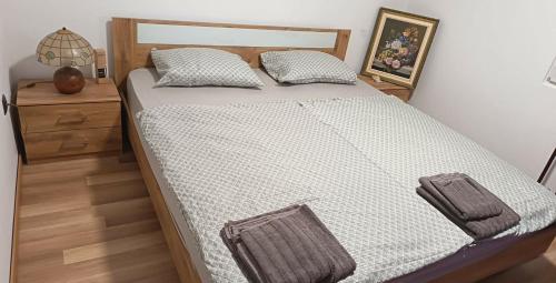 a bedroom with a large bed with a wooden headboard at Apartma TI & JAZ in Vrh