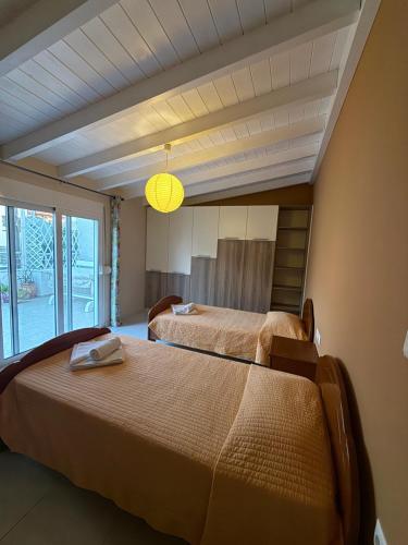 a bedroom with two beds and a large window at JORGO in Kremasti