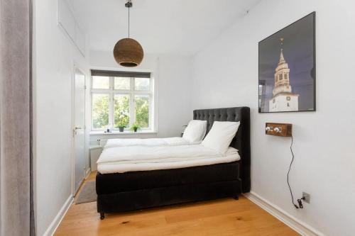 a bedroom with a bed in the corner of a room at Central Jylland Suite in Aalborg