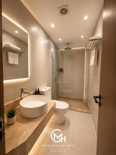 a bathroom with a tub and a toilet and a shower at Grand Museum Hotel Giza in Cairo