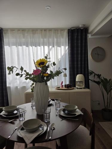 a dining room table with a vase of flowers on it at Calm Sun Apartment in Alpirsbach