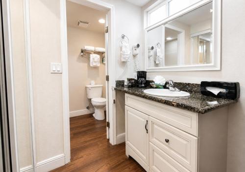 a bathroom with a sink and a toilet and a mirror at Pea Soup Andersen's Inn in Buellton