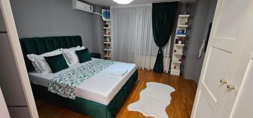 a small bedroom with a bed with a green headboard at Apartament Victoriei - Centru in Bucharest