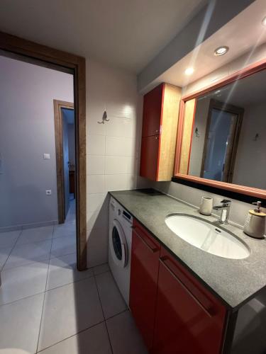 a bathroom with a sink and a washing machine at JORGO in Kremasti