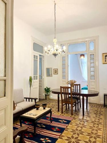 a living room with a table and a chandelier at Per-en in Cairo