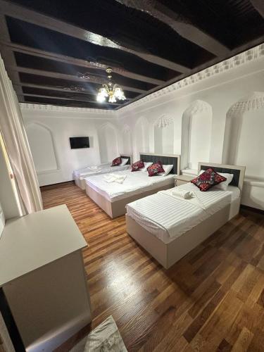 a room with two beds and a table at Merik Boutique in Bukhara