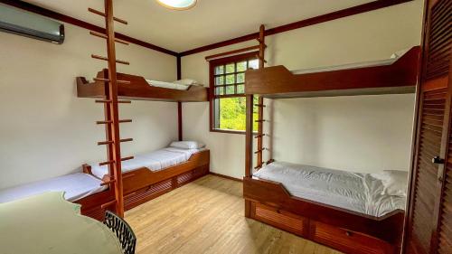 two bunk beds in a room with a window at Casa 02 Vale Boa Vista - Casa em Condomínio Exclusivo com Vista para as Montanhas e Área de Lazer Completa in Teresópolis