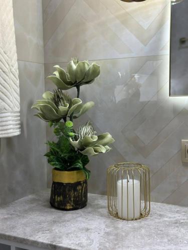 a vase with plants on a counter in a bathroom at Guesthouse TEA in Kutaisi