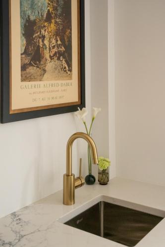 a kitchen sink with a gold faucet at Manoir Émery in Montreal
