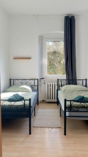a bedroom with two beds and a window at Worker's Dream Apartment in Kirchenlamitz