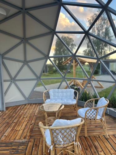 a screened in porch with chairs and a table at Poilsio oazė Stebuliuose in Stebuliai