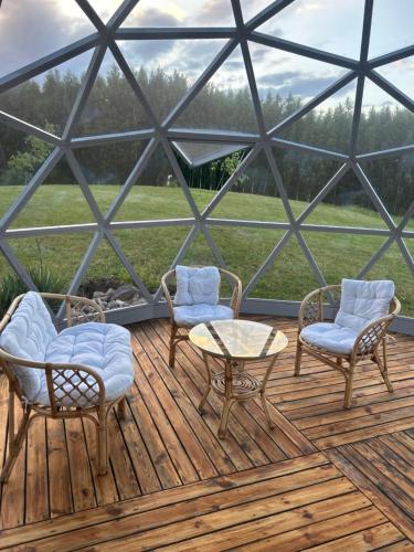a glass igloo with two chairs and a table and two chairs at Poilsio oazė Stebuliuose in Stebuliai