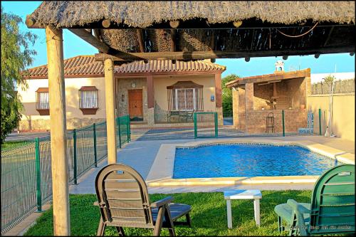 una piscina con sillas y una casa en Mi Oasis, en Conil de la Frontera