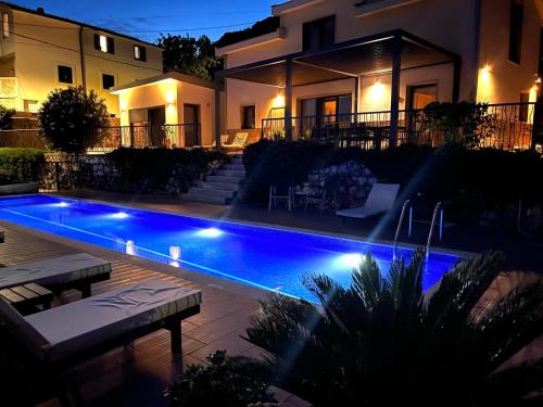 a swimming pool in front of a house at night at Villa Mattson in Budva