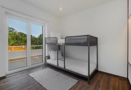 a white room with a bed and a window at Cascais, Family retreat in a 2-bedroom apartment in Alcabideche
