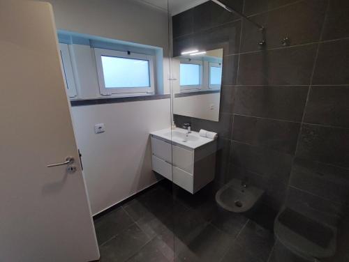 a bathroom with a sink and a mirror and a toilet at Cascais, Family retreat in a 2-bedroom apartment in Alcabideche