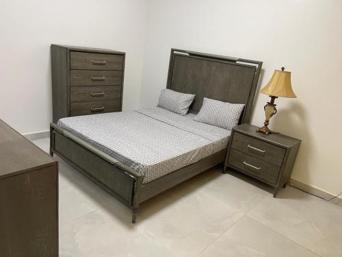 a bedroom with a bed and a dresser and a lamp at Résidence MuHamin in Ngaparou