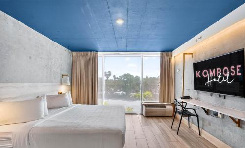 a hotel room with a large bed and a tv at Kompose Boutique Hotel Sarasota in Sarasota