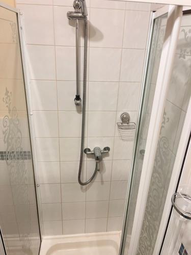 a shower with a glass door next to a toilet at Seaview Inn in Southport
