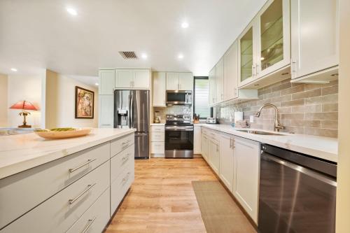 a large kitchen with white cabinets and stainless steel appliances at WAILEA ELUA, #1104 in Wailea