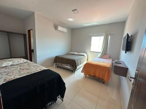 ein Hotelzimmer mit zwei Betten und einem Fenster in der Unterkunft Pousada Melk Beach in Luis Correia
