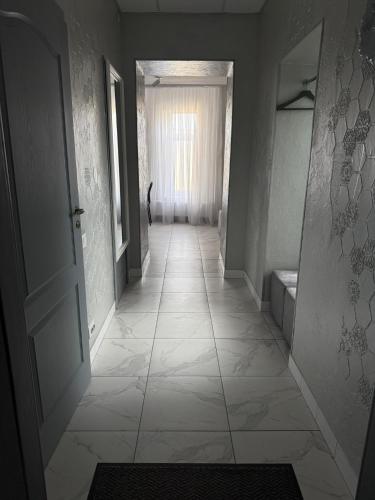 a hallway with a tile floor and an open door at Міні-готель RANDEVU in Zhytomyr