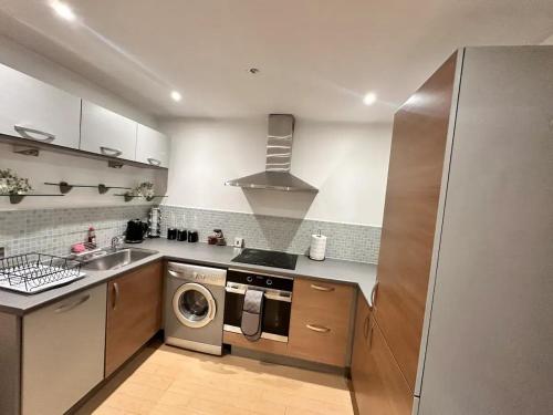 a kitchen with a sink and a washing machine at Bee Accommodations - NG1 Apartment in Nottingham