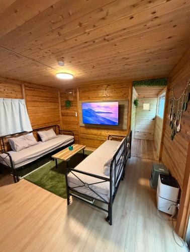 a room with a couch and a tv in a cabin at Kozakura Cottage II in Hamamatsu