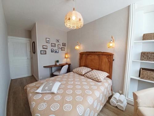 a bedroom with a bed with a wooden headboard at Le Chapitre in Châteaumeillant