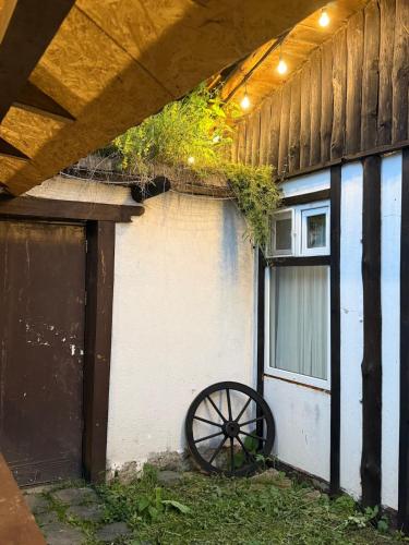 an old wagon wheel sitting next to a building at Zartak cottage in Dilijan