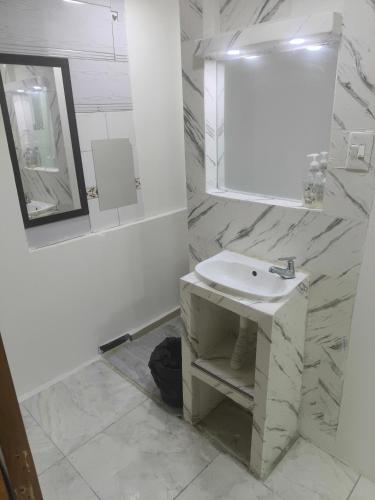 a white bathroom with a sink and a mirror at Continental Aparta Hotel Duitama in Duitama