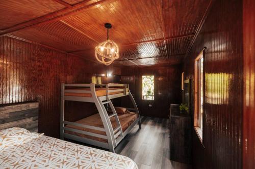 a bedroom with two bunk beds and a chandelier at Naranjito River Retreat Events & Groups Sleeps 13 in Naranjito