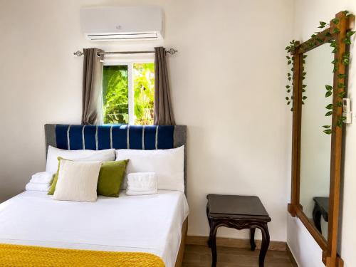 a bedroom with a bed with a mirror and a window at Villas Don Che, 2 villas in Jarabacoa