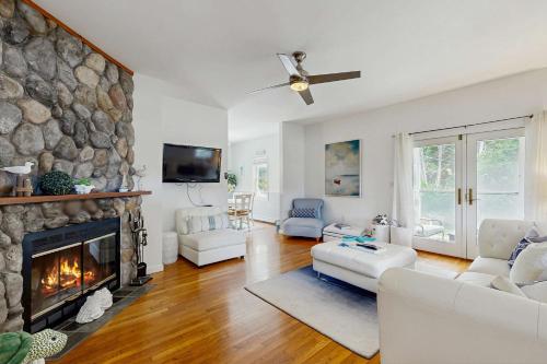 a living room with a fireplace and a stone wall at Sunny Side Up in Oak Bluffs