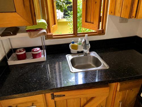 a kitchen counter with a sink and a window at Villas Don Che, 2 villas in Jarabacoa