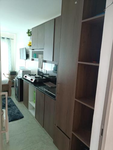 a kitchen with wooden cabinets and a stove top oven at Le Kirstel Suites in Kiambu