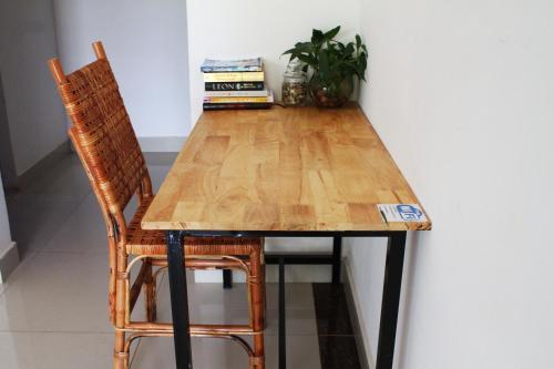 a wooden table with two chairs and a plant at My Parents Guesthouse in Kampot