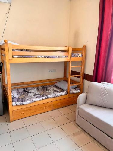 zwei Etagenbetten in einem Zimmer mit einer Couch in der Unterkunft Ruma Hotel in Yerevan