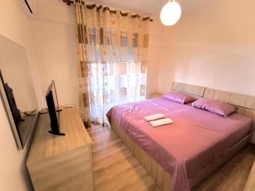 a bedroom with a bed with two towels on it at Astir Apartments in Tirana