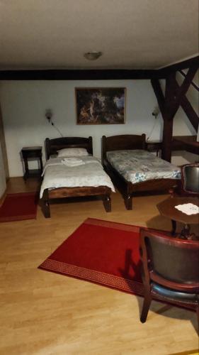 a living room with two beds and a table at Vila Olga in Sombor