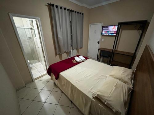 a bedroom with a bed and a television in it at Pé da Serra Hotel in Resende