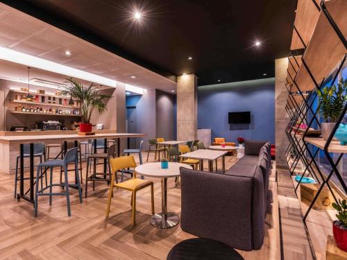 a restaurant with tables and chairs and a bar at ibis Chia in Chía