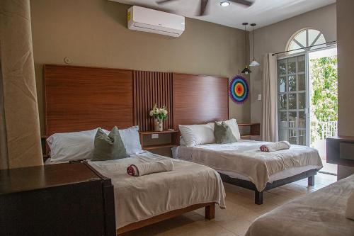a hotel room with two beds and a window at Villas Aura in Mérida