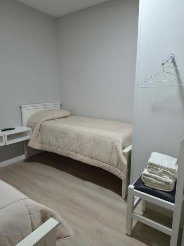 a bedroom with two beds and a table with a mirror at Tortugas Hotel in Carlos Casares