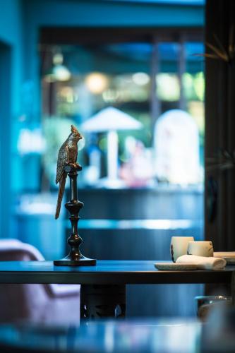 a figurine of a bird sitting on top of a table at La Mare aux Oiseaux, The Originals Collection in Saint-Joachim