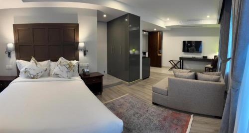 a bedroom with a large bed and a living room at Pak Hospitality in Islamabad