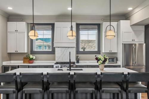 a kitchen with white cabinets and a table with chairs at 7BR City Condo & Pool Access Near CBD in New Orleans