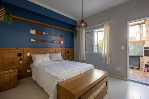 a bedroom with a bed and a blue wall at Flat completo e charmoso no centro de Juquehy in São Sebastião
