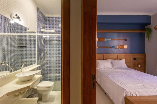 a bathroom with a bed and a sink and a toilet at Flat completo e charmoso no centro de Juquehy in São Sebastião