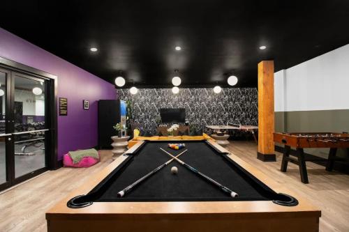 a pool table in a room with purple walls at King Bed Prime Location Downtown Hotel Suite in New Orleans